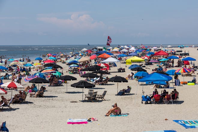 Tents and umbrellas are dotted along the sand as visitors enjoy the Tybee Island beaches on Saturday July 4th.