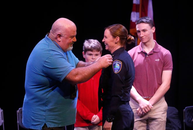 Recently retired Tybee police chief Bob Bryson pins the chief's badge on new police chief Tiffany Hayes during a ceremony on Friday January 13, 2023 at the Tybee Post Theater.